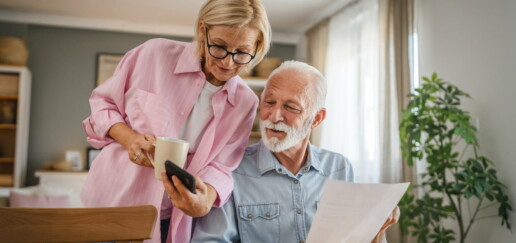 couple looking at smart phone and direct mail