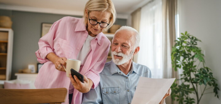couple looking at smart phone and direct mail