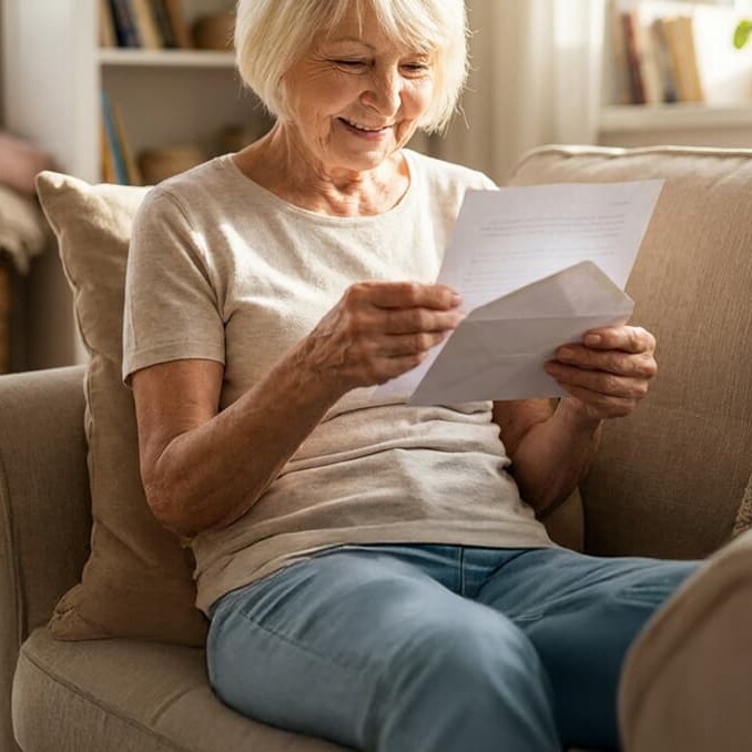 Senior woman looking at received mail at home